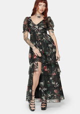 Woman wearing a fruit printed maxi dress with a white background