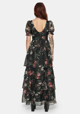 Woman wearing a fruit printed ruffle maxi dress with a white background