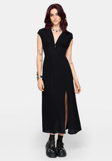 Woman wearing a black dress with a thigh high slit on a white background