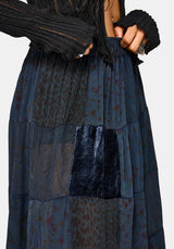 Long, dark blue patchwork skirt with a person wearing it against a light gray background