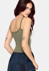 Woman wearing a khaki sleeveless vest with thin straps, cropped length and blue butterfly embroidery in center against a white studio background