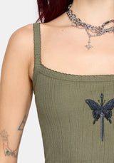 Woman wearing a khaki sleeveless vest with thin straps, cropped length and blue butterfly embroidery in center against a white studio background