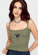 Woman wearing a khaki sleeveless vest with thin straps, cropped length and blue butterfly embroidery in center against a white studio background