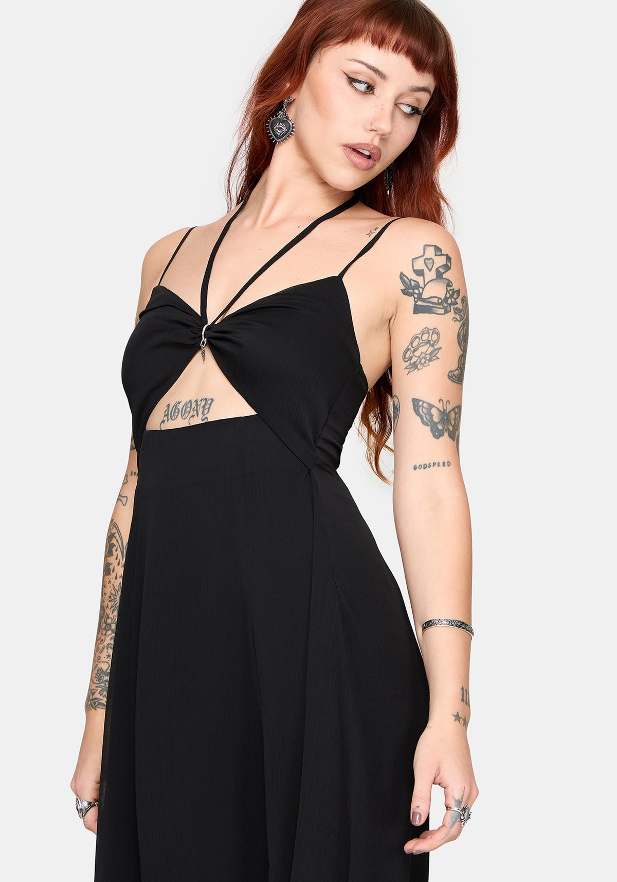 Woman wearing a black dress with thin straps on a white background