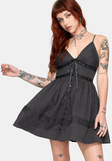 Woman wearing a charcoal dress with a white background