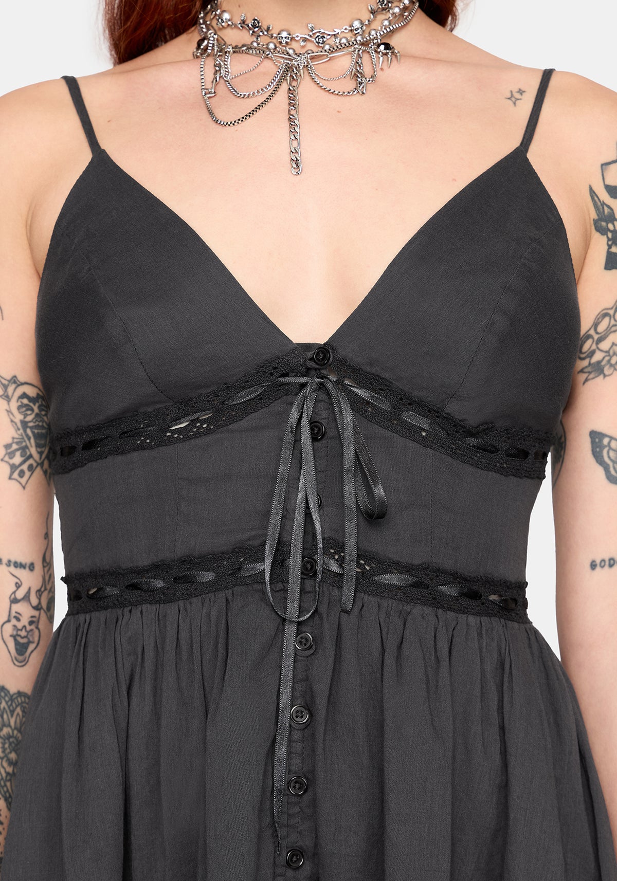 grey dress with lace details and buttons, worn by a person with tattoos.