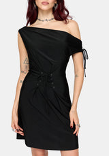 A woman wearing a black off-the-shoulder mini dress with a lace-up front detail, shown against a light gray studio background.