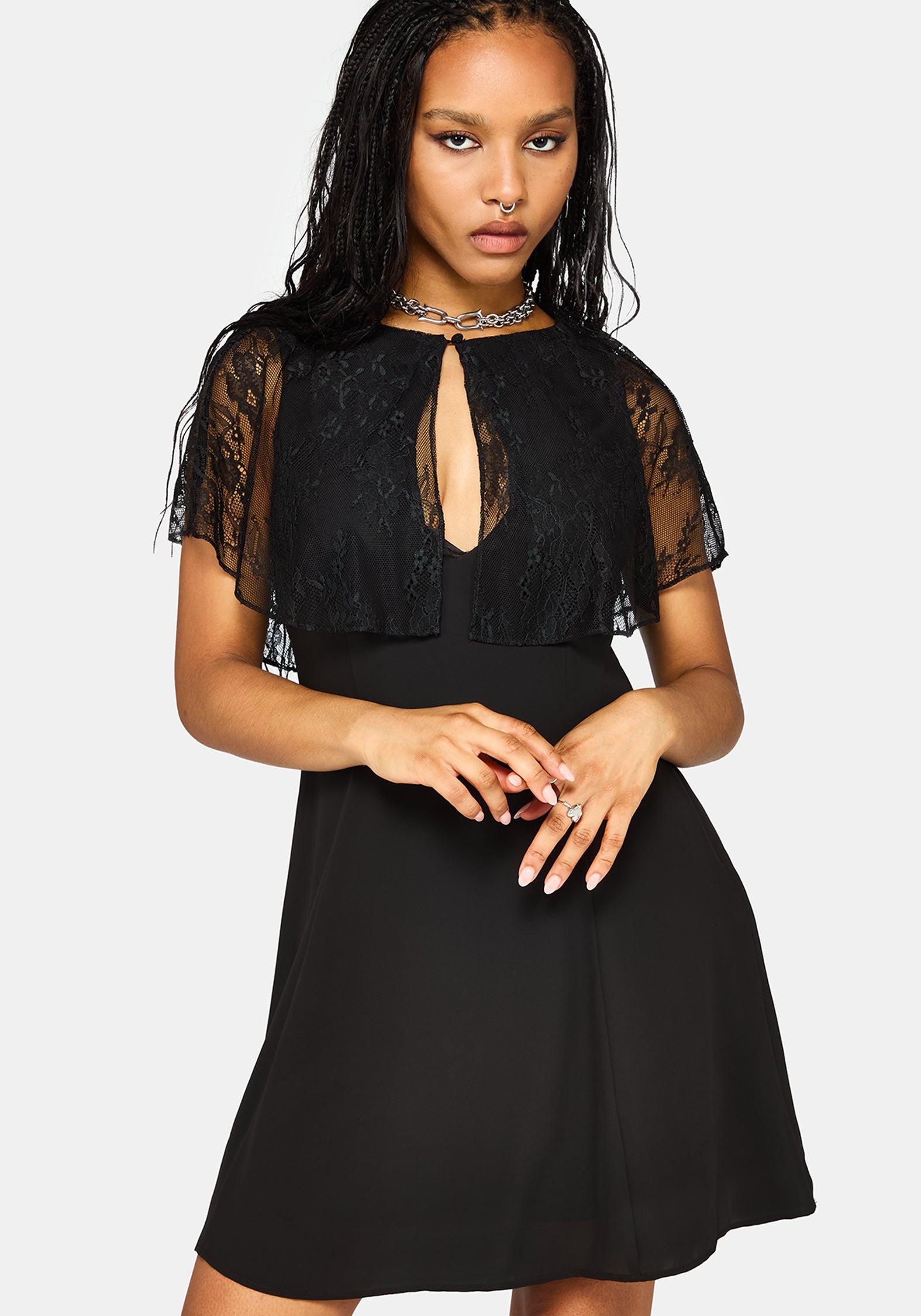 A woman modeling a black dress with sheer lace flutter sleeves, a keyhole cutout at the neckline, and a flared skirt, photographed against a light gray studio background.