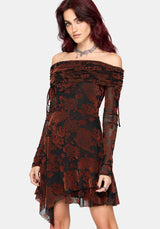 A woman modeling an off-the-shoulder long-sleeve dress with a burnt orange and black floral flocked pattern, set against a plain light gray background.