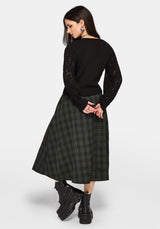 Woman wearing a black sweater and plaid skirt on a white background