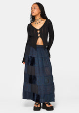 Woman wearing a black cardigan and layered navy skirt on a white background