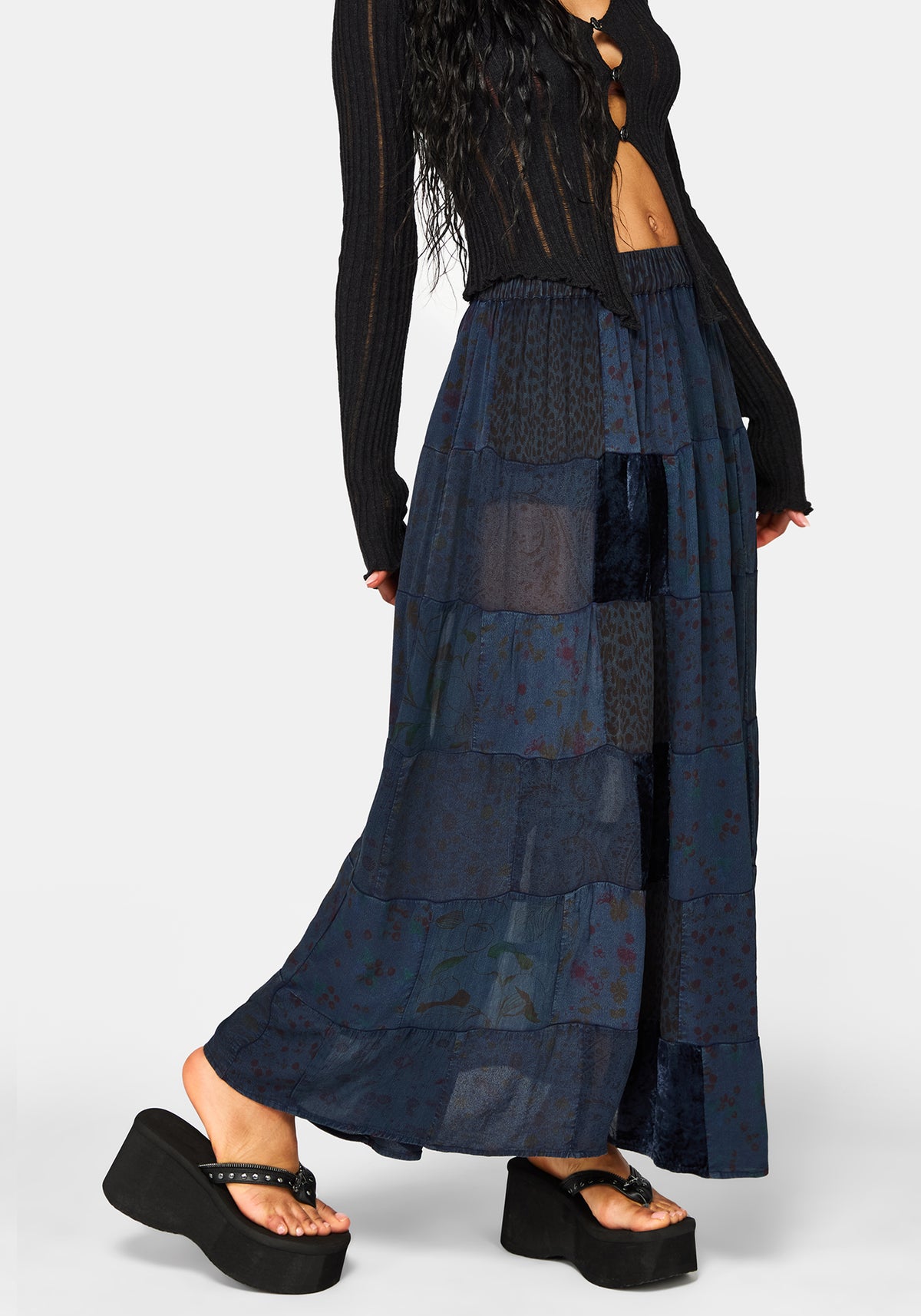 Model wearing a long navy blue skirt with a white background