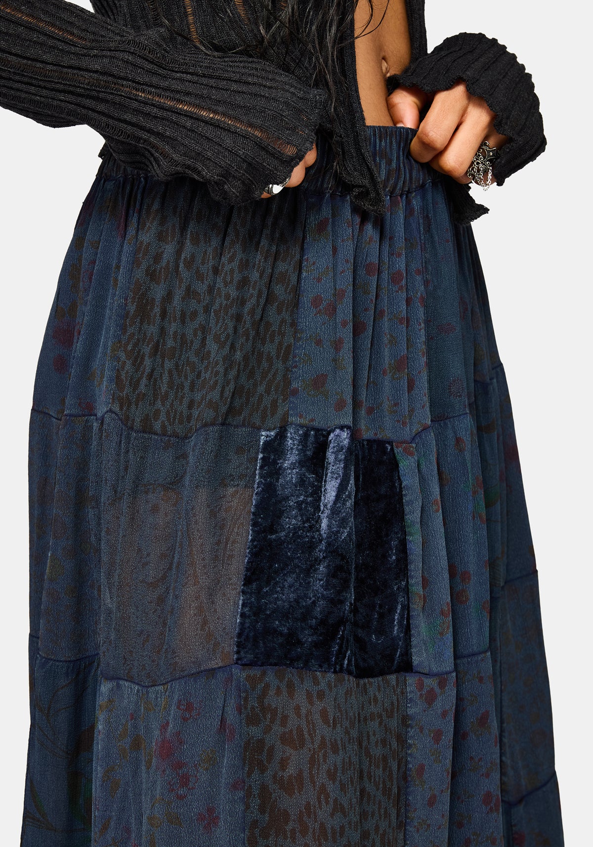 Long, dark blue patchwork skirt with a person wearing it against a light gray background